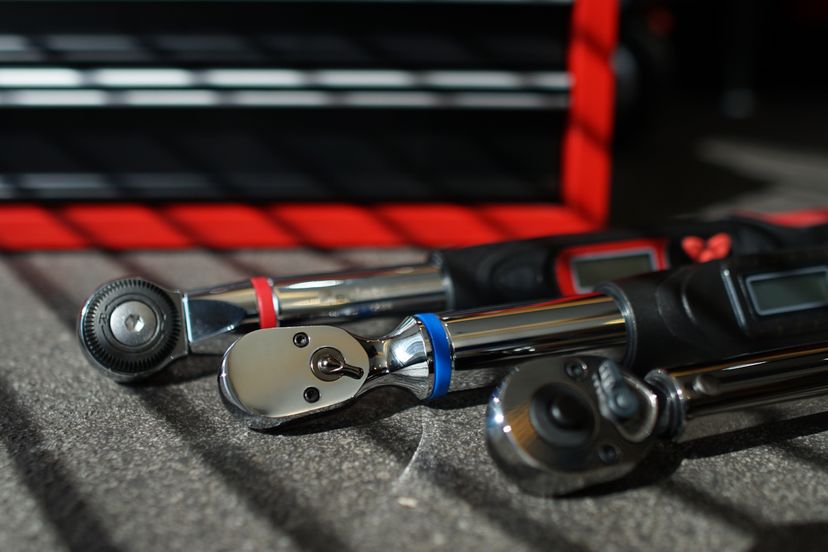 Three torque wrenches lying on a workbench.
