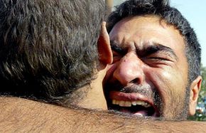 An Iraqi man hugs his brother in November 2005 after being freed from Abu Ghraib prison, a site where some prisoners were tied up, hooded and sexually degraded by the American military.