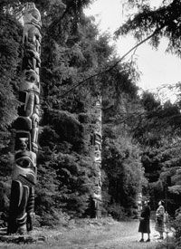 tourists admire totem poles