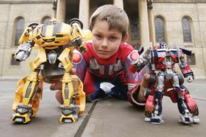 A boy plays with Transformers action figures. See more toy pictures.