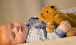 infant with teddy bear