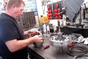 B.J. Allen takes apart a transmission at his business near Paducah, Ky.