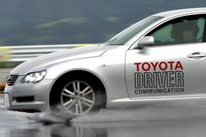 The Toyota Mark X is driven to demonstrate its VGRS safety system. VGRS, which stands for variable gear ratio steering, controls steering, braking and turning of the tires to reduce spinning and skidding when braking and turning on slippery surfaces.