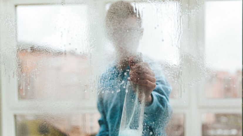 man cleaning windows at home