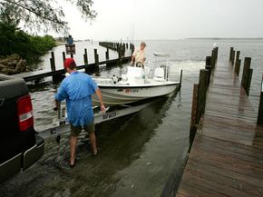 Two Floridians load their boat onto a trailer as they wait for Hurricane Wilma. Trailer bearing protectors should keep the boat's hubs clean in inclement weather.