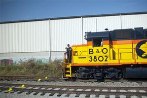 Train engineers stand at the front of a Baltimore & Ohio locomotive adjacent to the Baltimore & Ohio Transportation Museum located at the Mount Clare Station in Baltimore, Md.
