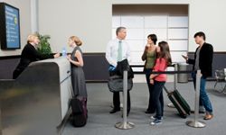 People at airline terminal gate waiting in line to board airplane.