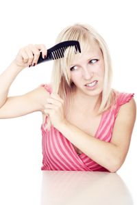 frustrated woman combing hair