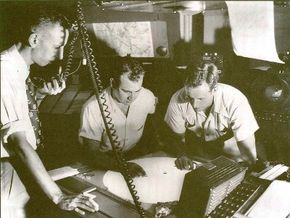 photo of men looking at a radar screen