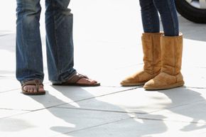 A man wearing sandals and a woman wearing UGGs on a hot summer day in London.