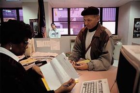 An office clerk peruses an application for unemployment in New York while the applicant waits. There are some tax breaks to offset the taxes on your unemployment checks.