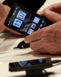 A visitor examines an HTC smartphone at the CeBIT Technology Fair in Hannover, Germany.