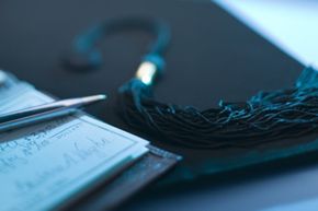 Mortarboard beside checkbook.