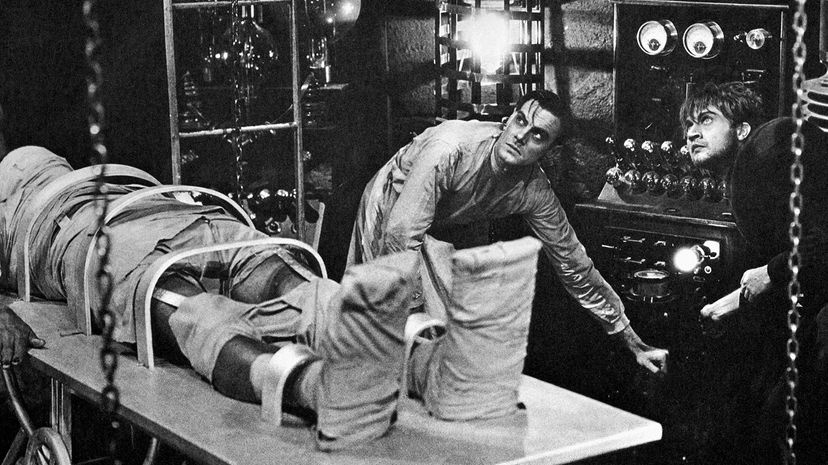 Colin Clive, as Dr. Frankenstein, and Dwight Frye, as his assistant Fritz, prepare to bring their monster to life in a scene from the 1931 movie 