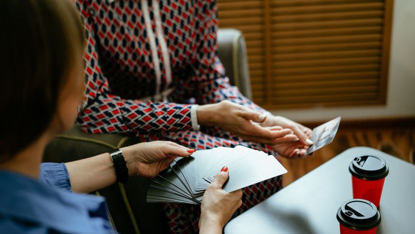 Two women holding tarot cards