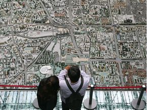 At the Planning and Exhibition Hall in Beijing, a pair of visitors examines a scale model of the city. 