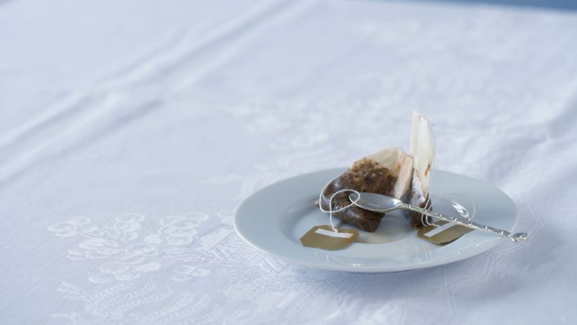 Used tea bag on saucer on table