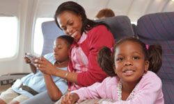 A mother and her kids entertain themselves on an airplane.