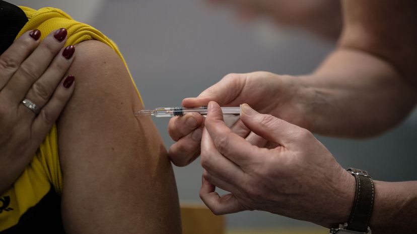 Postal workers receive a flu shot