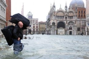 Man walking through flooded square in Venice