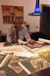 The managing director of CVN's lead consultant firm Technital examines aerial photographs of a lagoon.