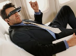 Advertisments tout that video glasses are perfect for long plane rides. This guy sure seems to be enjoying them.
