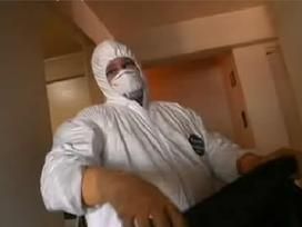 A man in a white hazmat suit wearing a mask.