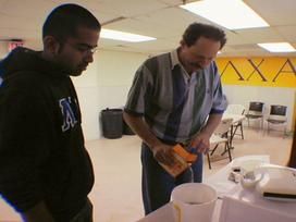 A teacher and student pour baking soda into a white container.