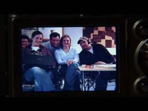 A photograph of a group of people is shown on the LCD screen of a digital camera.&nbsp;