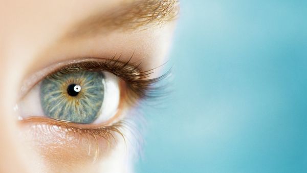 Closeup on the opened blue eye of a young woman