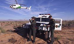 Border Patrol agents work with a helicopter flying overhead to police the border.