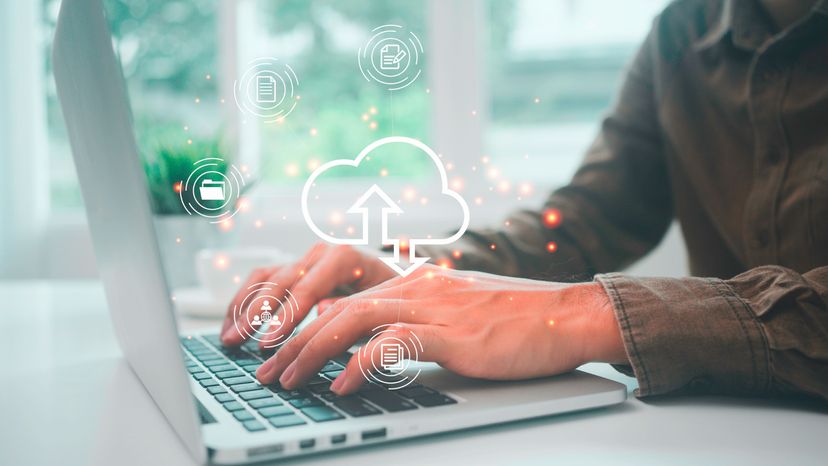 A man working on computer with cloud logo