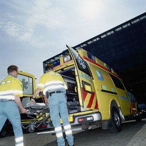 EMT's (Emergency Medical Technicians) lifting stretcher out of ambulance.