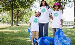 Family picking up trash in park. 