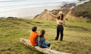 Hispanic park ranger talking to children