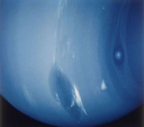 The Great Dark Spot on the surface of Neptune, as observed by the Voyager 2 spacecraft in 1989. The spot, thought to be a swirling mass of gases, had disappeared by 1994, to be replaced by a similar spot in a different location.