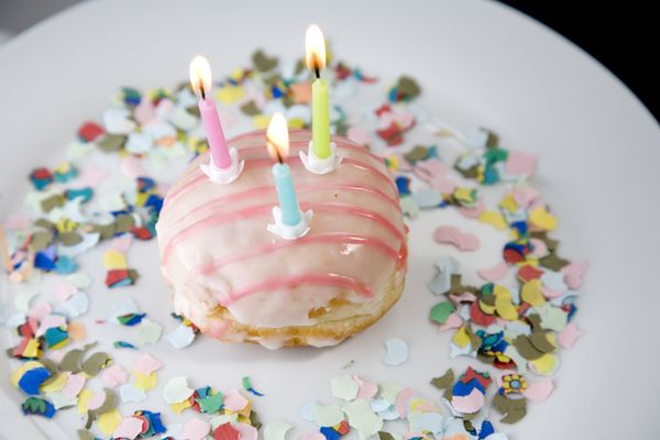 A doughnut with birthday candles is pictured.