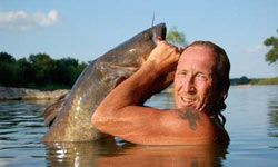 忘记钓鱼竿。When you go noodling, you use only your hands to "catch" huge catfish from the depths of the lake.”border=