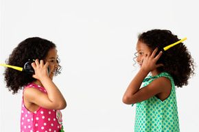 Two little girls talking on walkie-talkies