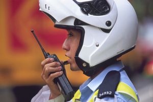 Helmeted security official using a walkie-talkie