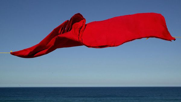 red sheet on clothesline by the ocean