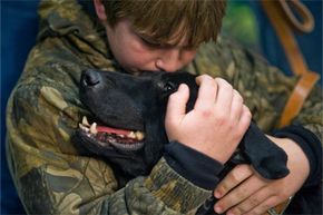 Brady Rusk, 12, hugs Eli, the bomb-sniffing military working dog his older brother Marine Pfc. Colton Rusk, worked with before being killed in action in Afghanistan.