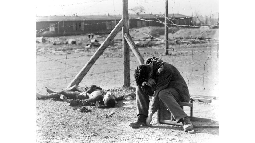 A Polish concentration camp survivor weeps near the charred corpse of a friend at the Leipzig-Thekla subcamp of Buchenwald in 1945. The Nazi SS guards set fire to barracks No. 5 there with approximately 300 prisoners locked inside just before the army's 69th Infantry Division liberated the camp. Margaret Bourke-White/Getty Images