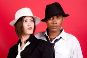 A man and a woman wearing hats defiantly.