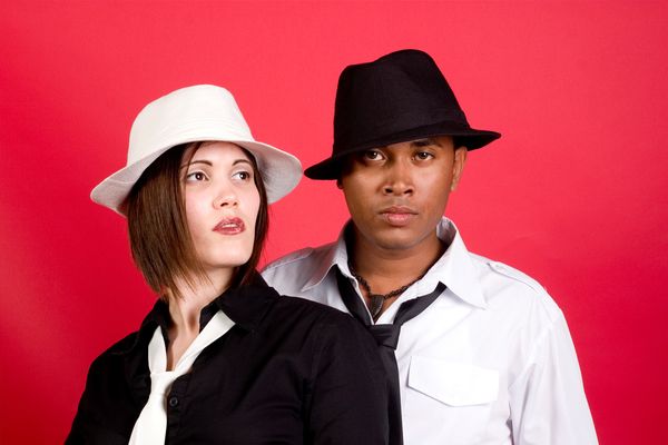 A man and a woman wearing hats defiantly.