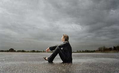 Person sits alone outdoors, overwhelmed with sadness and depression.