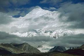 珠穆朗玛峰上升到对流层上层。雾蒙蒙的山景是一种常见的景象，因为海拔的突然升高有助于产生云层。＂border=