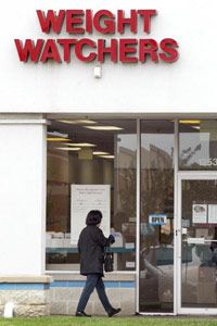 A client walks towards an entrance to a Weight Watchers meeting location May 18, 2004, in Arlington Heights, Illinois. With thousands of meetings around the country -- and the world -- dieters are able to find the support they need when they need it.
