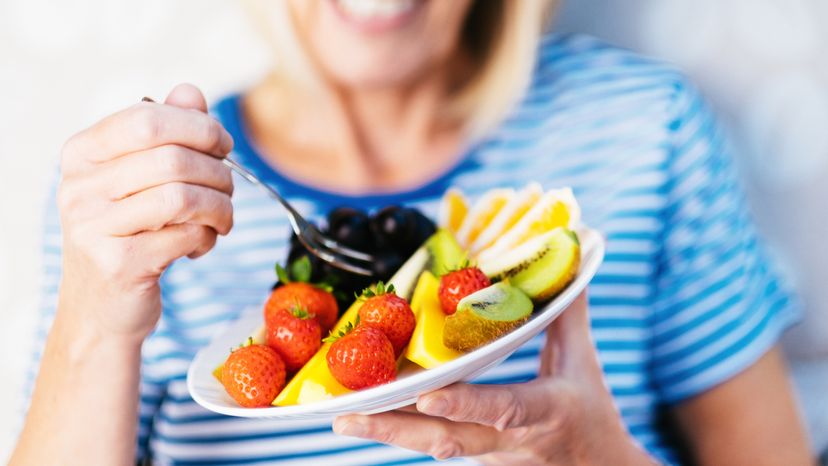 Attractive senior woman with fruit lunch
