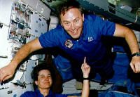 One astronaut &quot;lifts&quot; another with her finger.